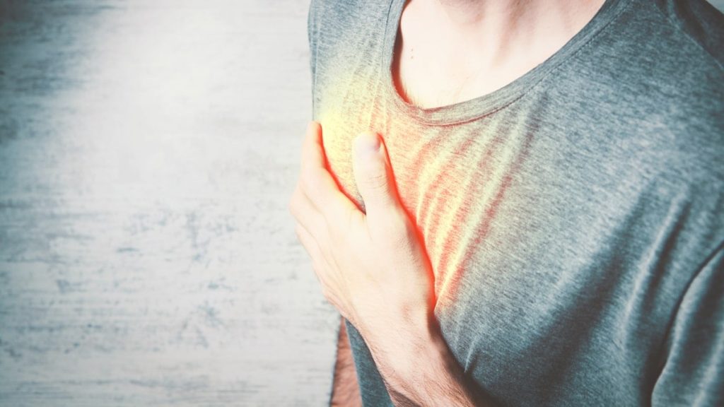 a man holding his chest with his hands
